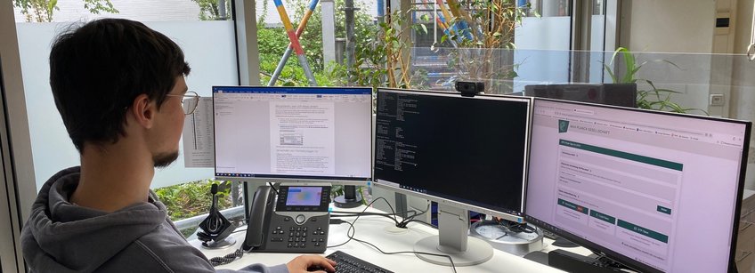 FachinformatikerInnen Systemintegration Auszubildender vor drei Bildschirmen