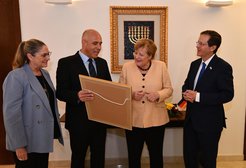 "Kanzlerin Merkel war sehr angetan von unserer Überraschung", sagt Alon Chen, Präsident des Weizmann Instituts (2.v.l.). Zusammen mit dem Israelischen Staatspräsidenten Isaac Herzog und dessen Frau, Michal Herzog, überreichte er die Urkunde.