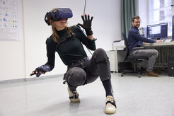 Eine virtual reality-Brille versetzt Florian Binders Kollegin Dorothee Pöhlchen in eine andere Welt. Beschleunigungssensoren an ihrem Körper messen ihre Bewegungen, die ein Computer in entsprechende Bewegungen ihres Avatars übersetzt.